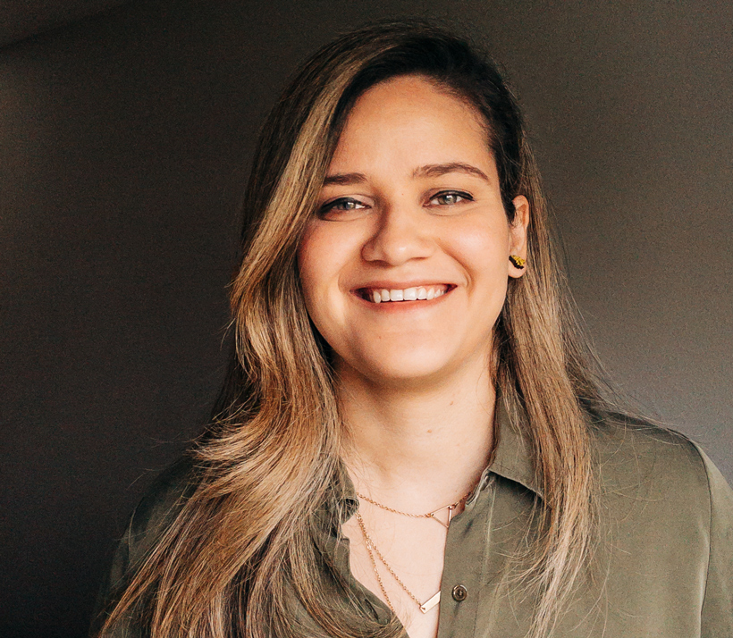 Retrato da Bianca, com um grande sorriso, olhando para a câmera.