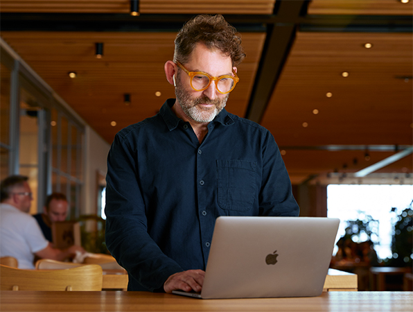 Ein Apple Teammitglied arbeitet in einem Caffè Macs an einem MacBook.