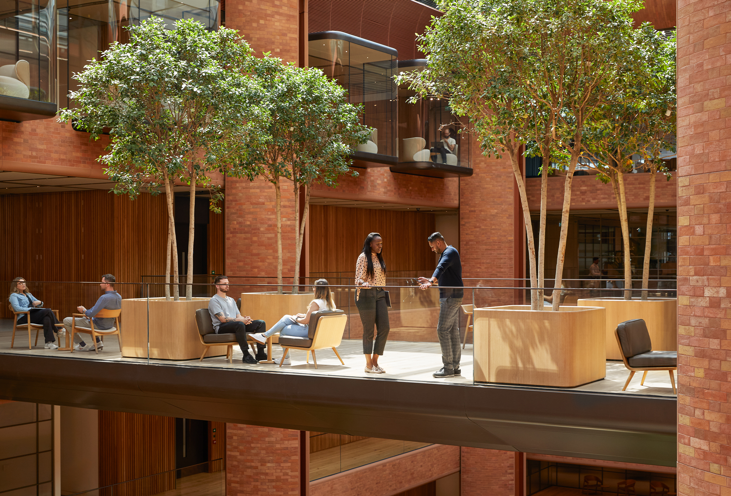 Mehrere Apple Teammitglieder sind im Battersea Atrium in Gespräche vertieft.