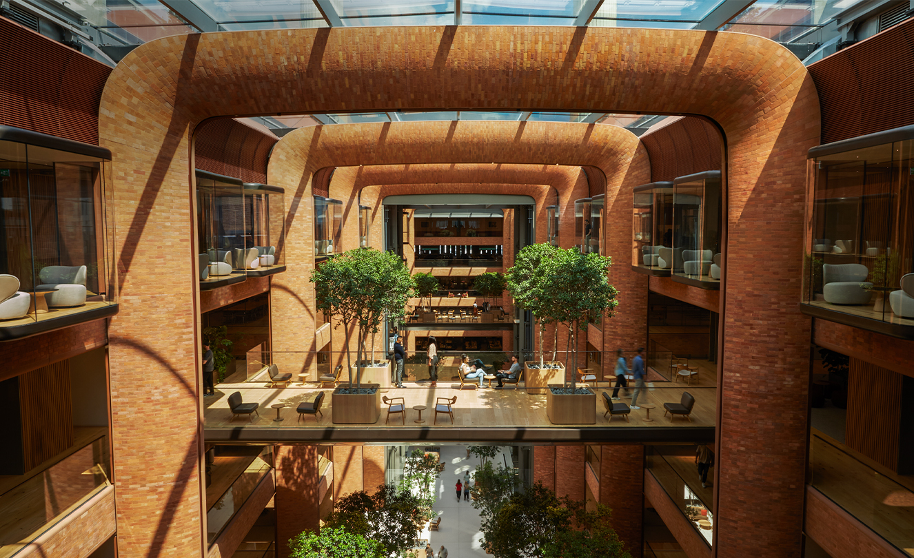 Das fünfstöckige Battersea Atrium, in das die Sonne durch das Glasdach scheint und Licht auf die Teammitglieder darunter wirft.