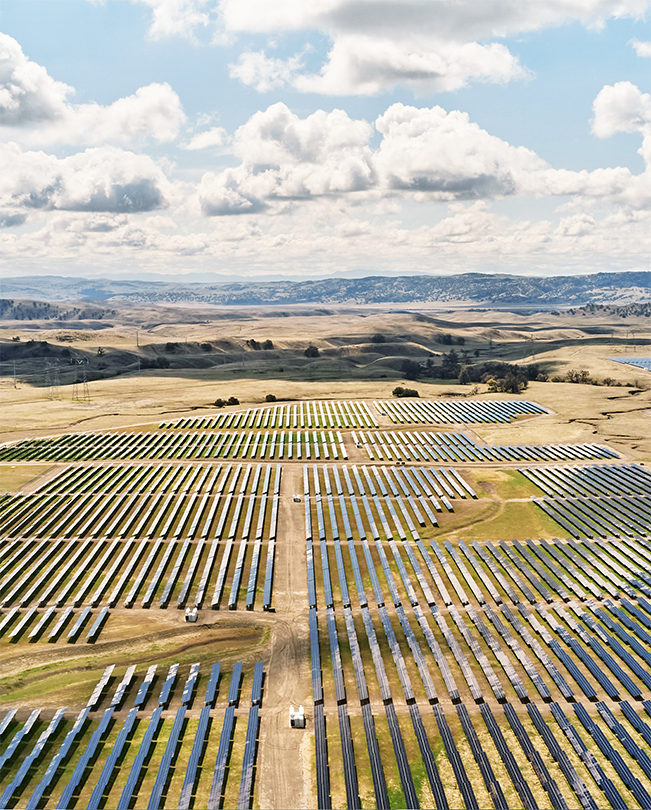 Vista aérea de un gran parque solar lleno de paneles produciendo energía.