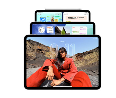 Tres modelos de iPad en posición horizontal, uno detrás del otro, y un Apple Pencil acoplado magnéticamente a la parte superior en el modelo más alejado. La pantalla delantera muestra la pantalla de bloqueo con efecto Liquid Glass, la pantalla del medio muestra la pantalla de inicio con widgets y la pantalla del fondo muestra dos apps, una al lado de la otra, como ejemplo de mosaico de ventanas.
