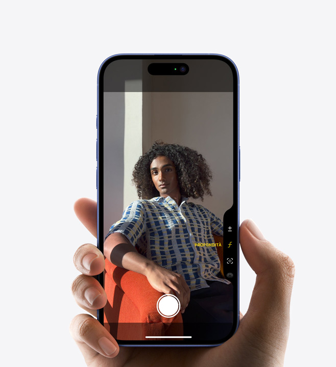 Un iPhone 16 Pro con un pollice appoggiato sul tasto del Controllo fotocamera per regolare la profondità di campo.
