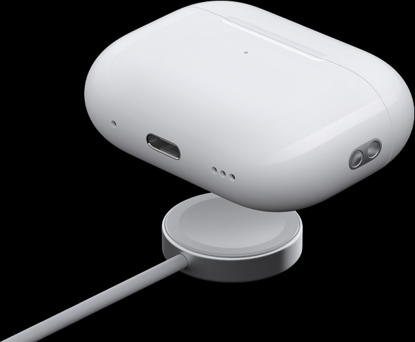 Vista prospettica a tre quarti della custodia di ricarica MagSafe che mostra l’altoparlante, l’anello per laccetto e la porta USB-C; la custodia è sospesa sopra il disco di un cavo per la ricarica di Apple Watch.