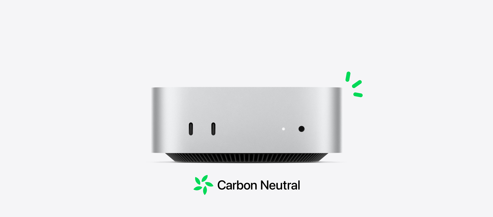 Vista frontal de una Mac mini color plata con puertos delanteros y una ilustración con pequeñas líneas verdes que representa su neutralidad en carbono.