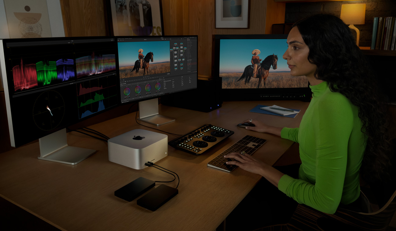 Una profesional usa la Mac Studio para editar archivos en tres monitores