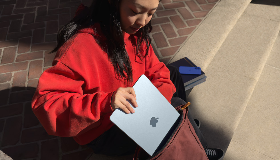 Ученик, поставящ MacBook Air в раницата си