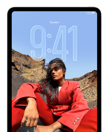 Un iPad muestra la pantalla bloqueada con grandes números de la hora que aparecen detrás de la foto de una persona sentada