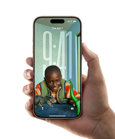 A hand holding an iPhone device which displays the new Liquid Glass design that lets the time dynamically adapt to the image on the Lock Screen