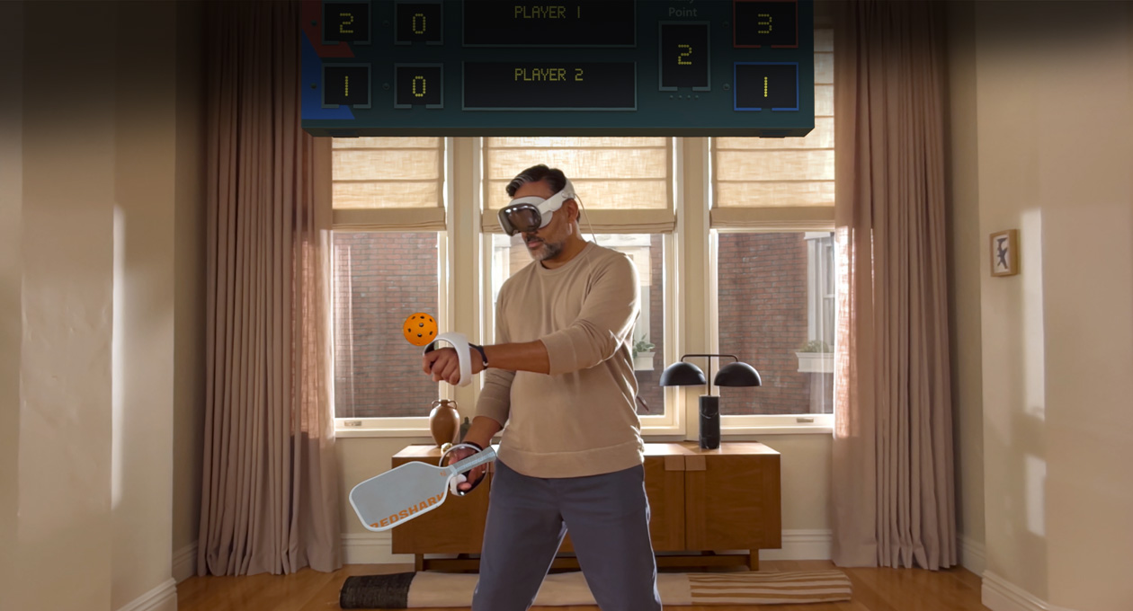 Apple Vision Pro와 Sony PlayStation VR2 Sense 컨트롤러를 착용하고 Pickle Pro 게임을 하는 남자의 모습, 그리고 그 위에 떠 있는 공간 점수판